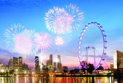 Singapore Flyer and the city skyline at dusk with fireworks in the background