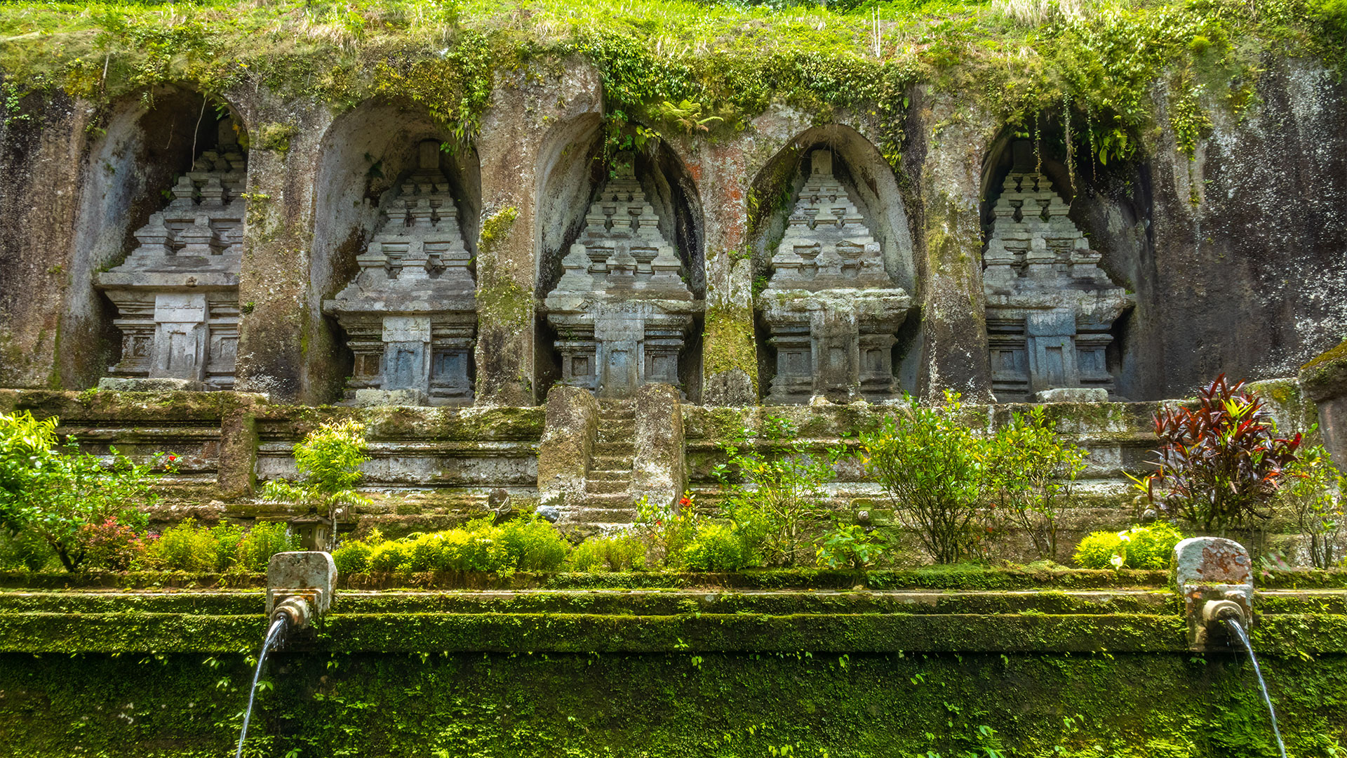 Shrine reliefs carved directly into the face of a rock cliff at Gunung Kawi Temple, Bali, Indonesia