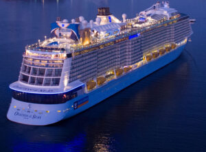 Aerial view of RCI Cruise Ship, Ovation of the Seas sailing into a harbour at dusk