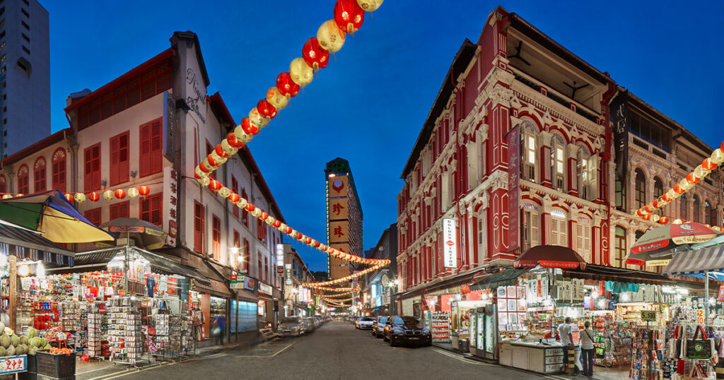 Lit-up yellow and red lanterns along a street in Chinatown at dusk, Singapore.